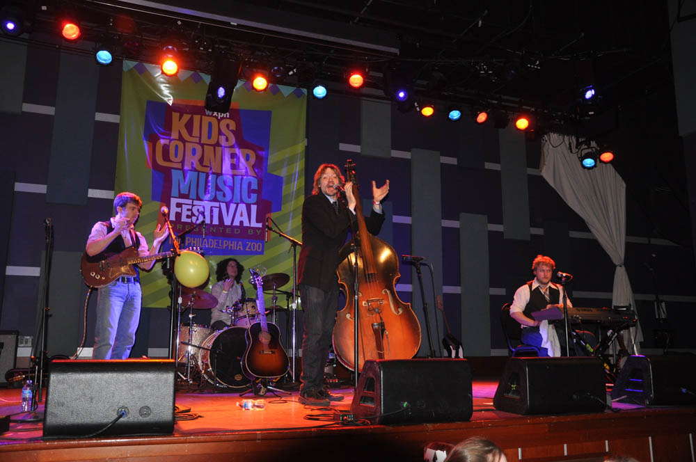 Kids Corner Music Festival banner with band playing