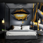 Bed in front of a black and white image of a woman’s lips with gold liquid dripping. 