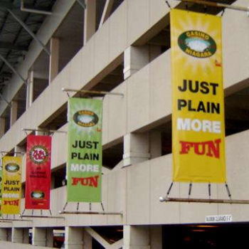 Multiple hanging vertical signs off parking garage with different colors of the same casino advertisement