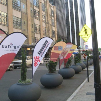 Multiple flag banners in the middle of a downtown area